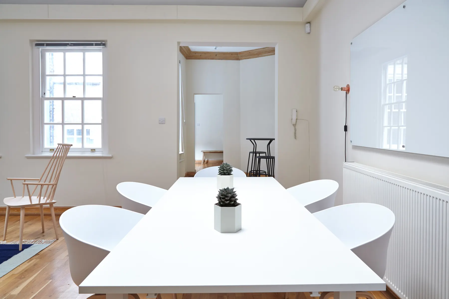 Bright meeting room with a long white table set up for a client review
